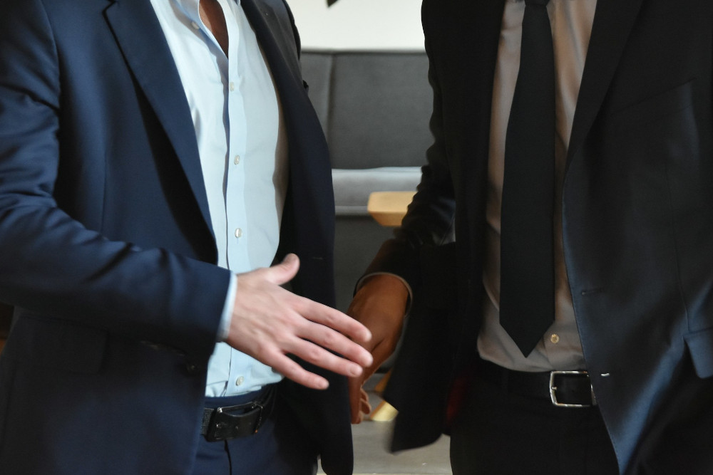 deux hommes se serrant la main suite à la vente d'un portefeuille d'assurance